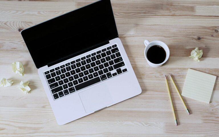 Mac maskin og kaffikopp. Foto